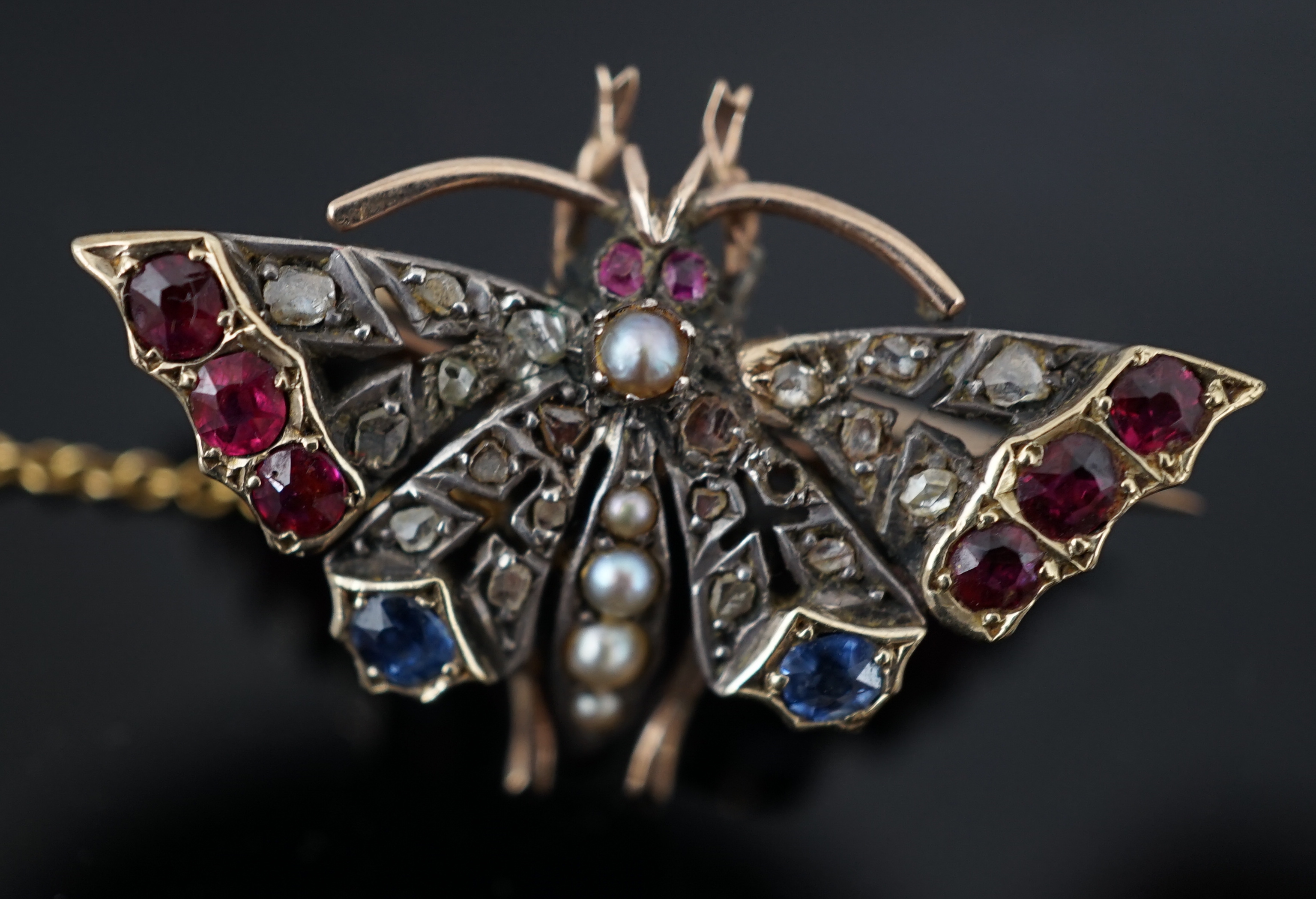 A Victorian gold, ruby, sapphire, split pearl and diamond cluster set butterfly brooch